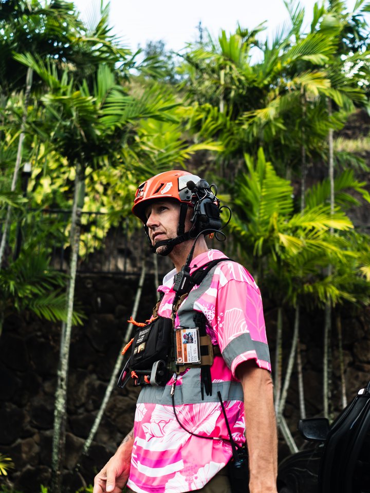 Crew leader in a pink aloha-print safety shirt and helmet at a Hawaii job site