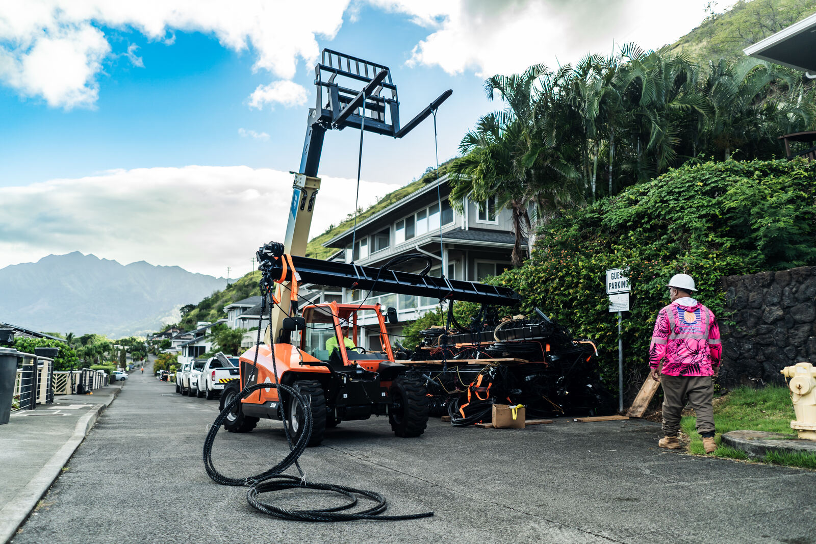 Telehandler staging barrier sections on a residential street