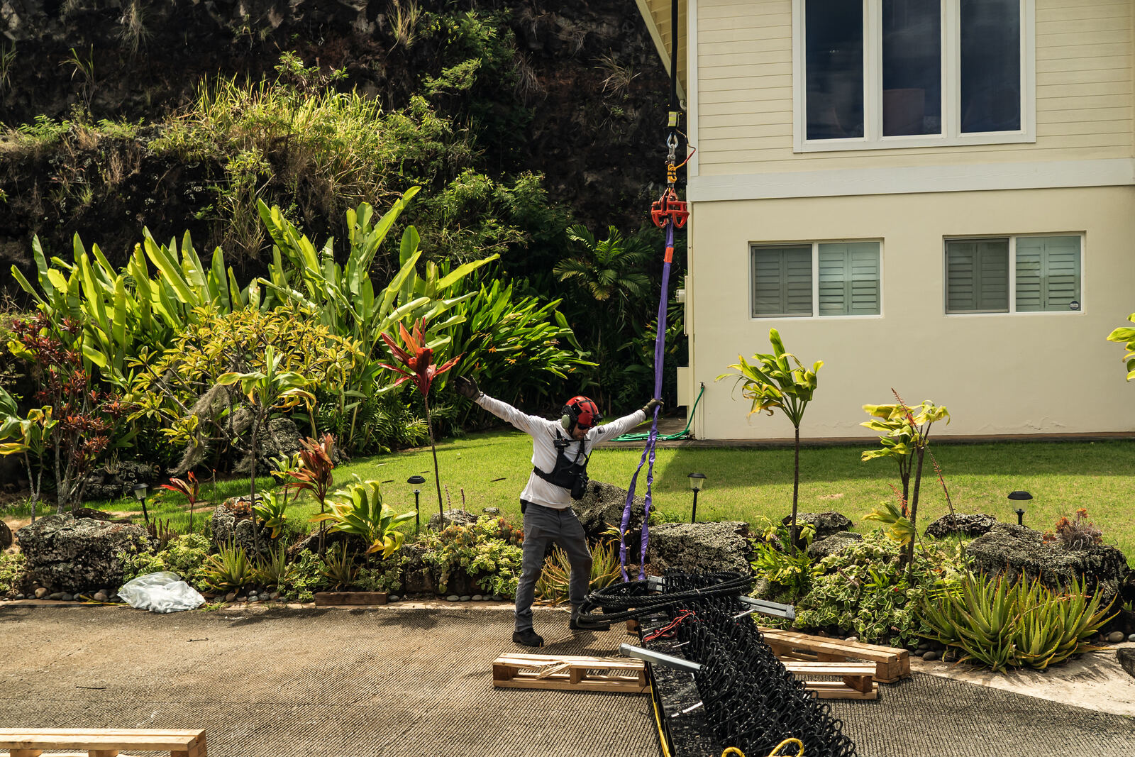 Crew member signaling beside a barrier section in a driveway